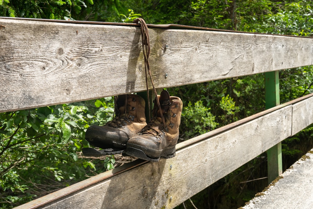 brown leather boots on wooden fence