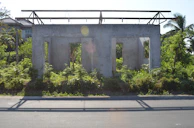 A clean, level concrete slab ready for a new home build, set against a backdrop of lush Oahu greenery.