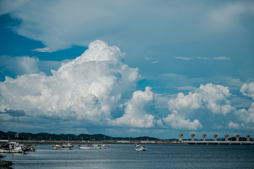 昼間の白い雲と青い空の下の海の白いボート