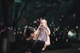 girl in black and pink dress blowing bubbles