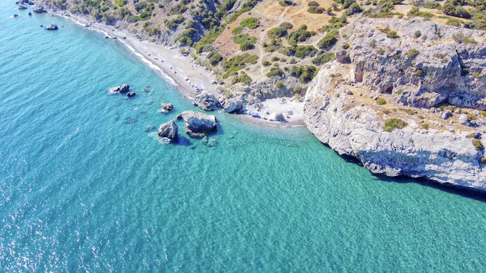 A rocky headland and clear water from the air.