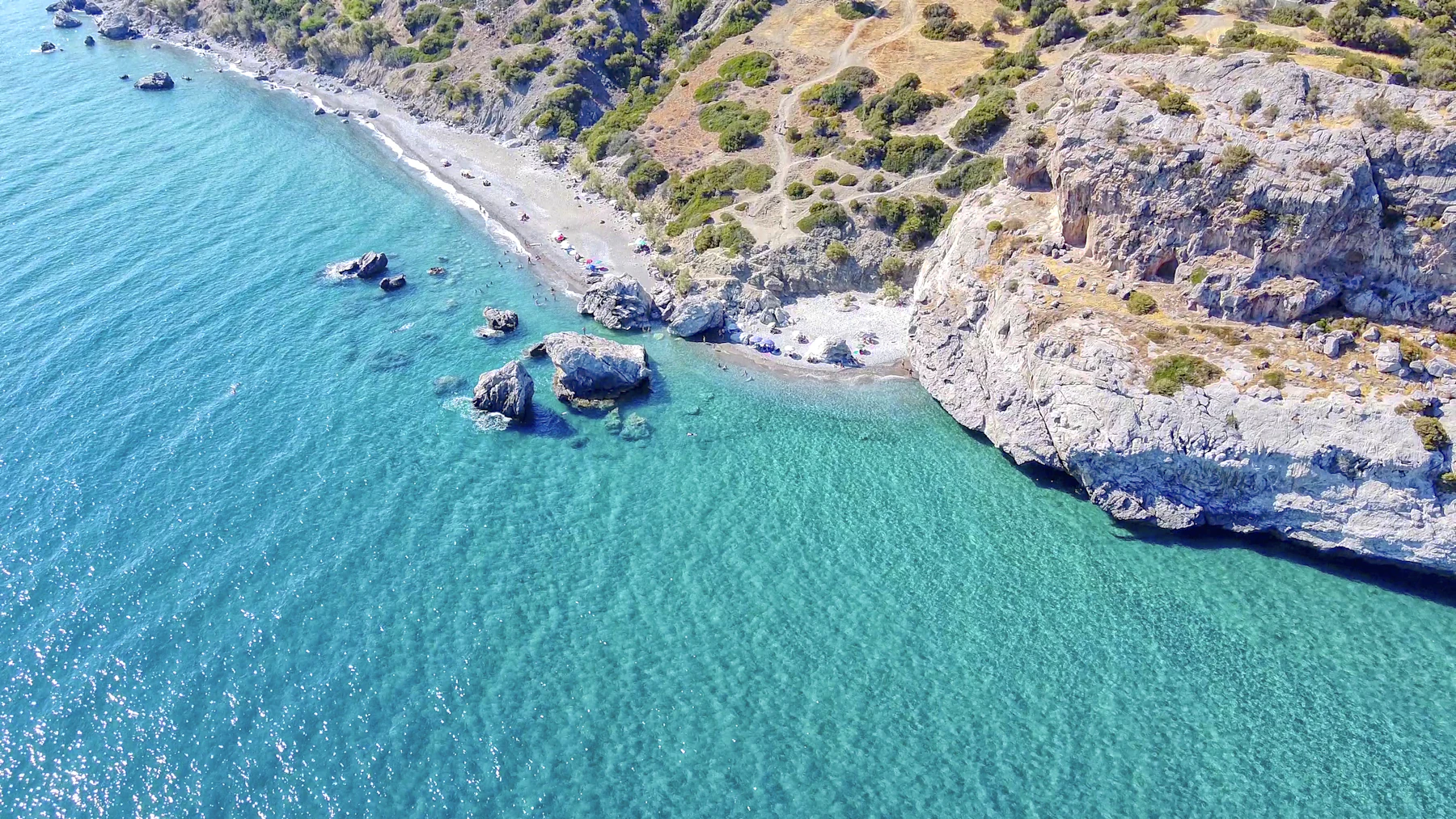 A rocky headland and clear water from the air.