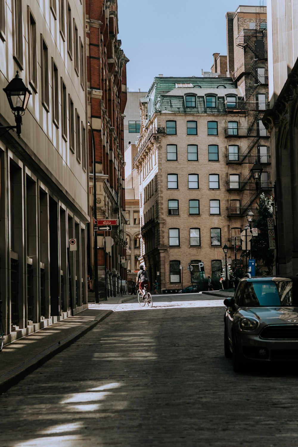 cars parked on side of the road in front of high rise building during daytime