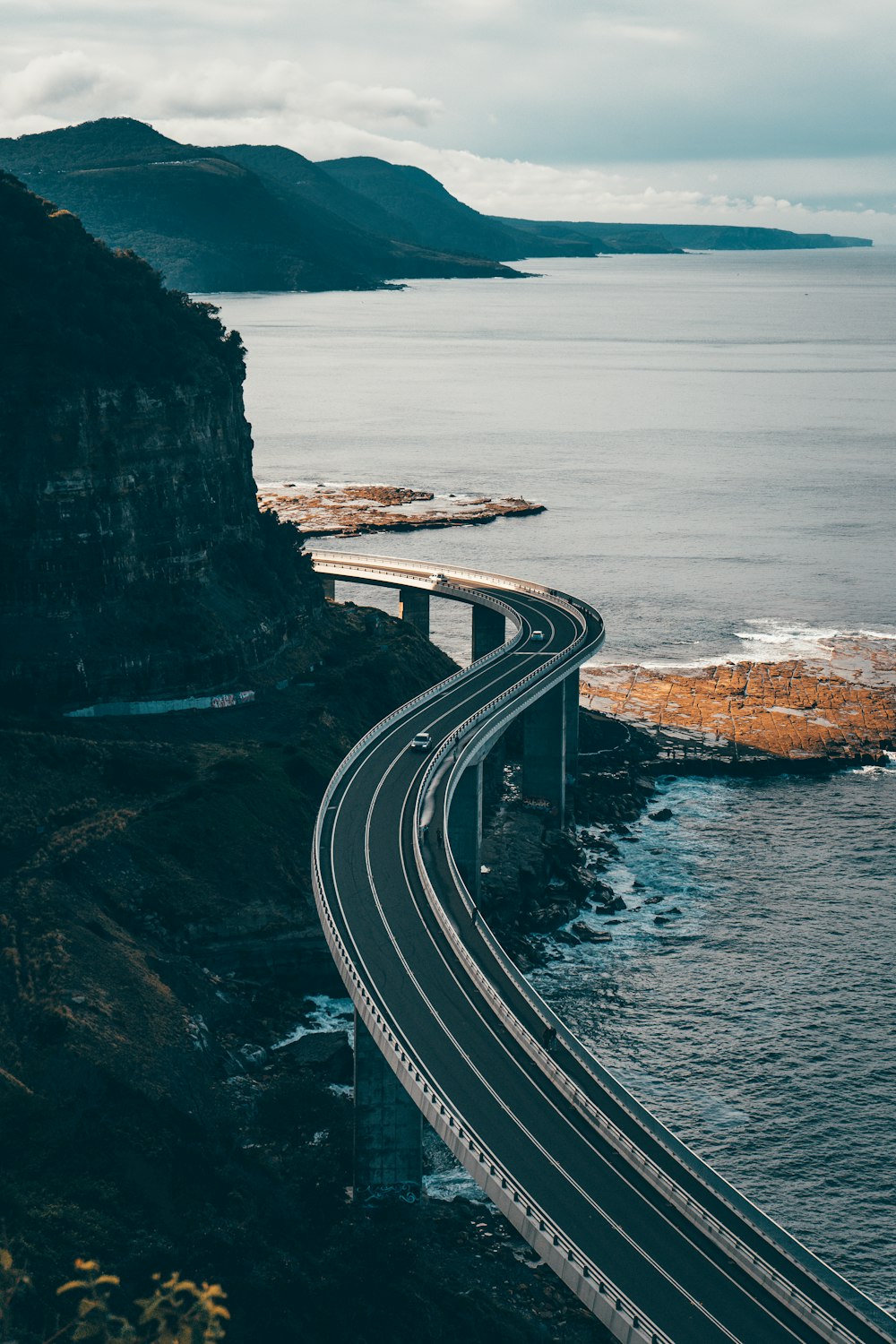 Carretera en blanco y negro cerca del cuerpo de agua durante el día