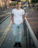 Image of a person standing on a city sidewalk wearing a clean, unbranded casual street t-shirt.