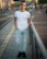 Image of a person standing on a city sidewalk wearing a clean, unbranded casual street t-shirt.