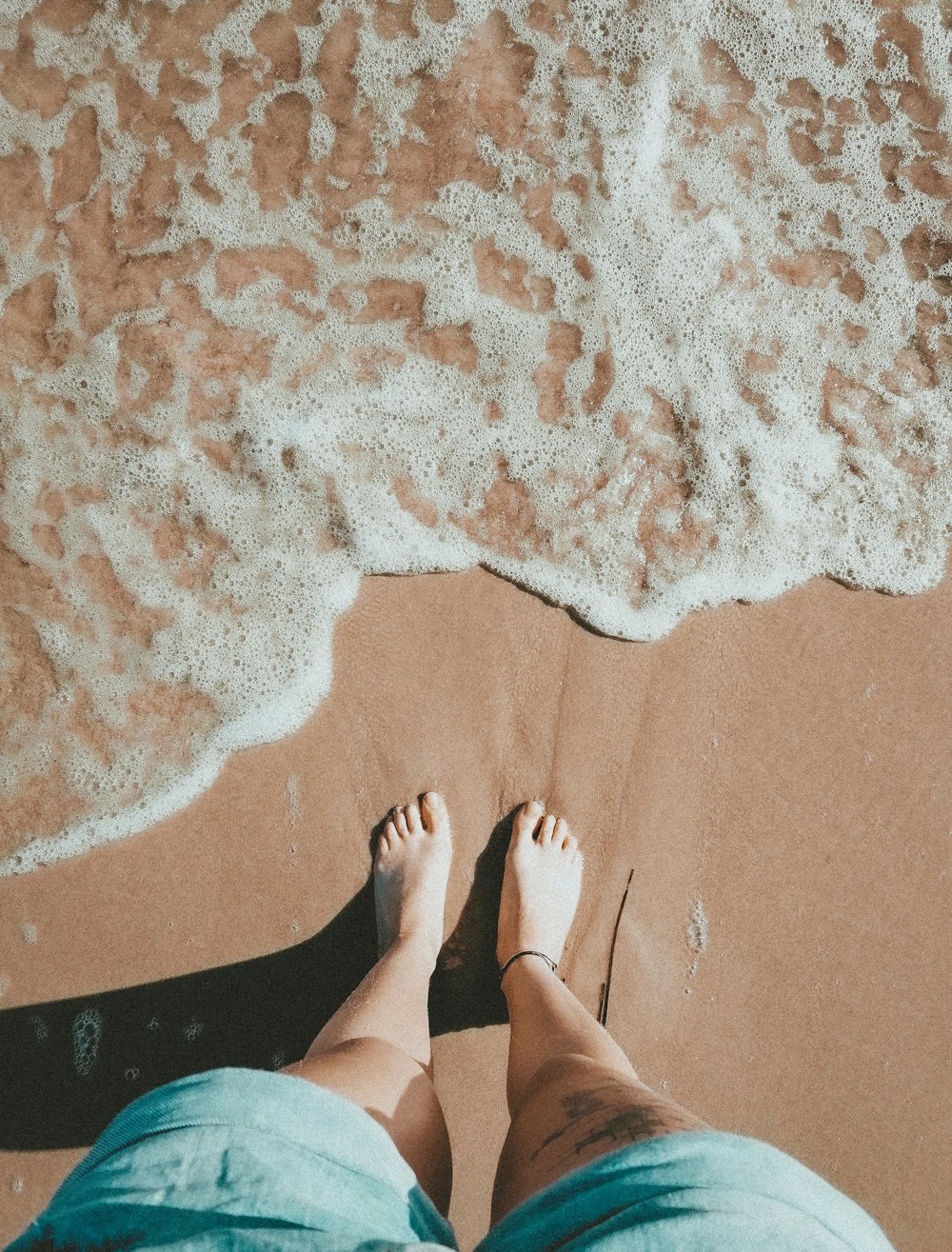 person standing on brown sand