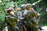 Soldiers engaging in a tactical drill in the forest.