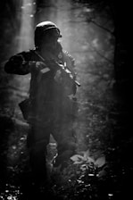 A rugged soldier silhouette against a smoky battlefield at dawn.