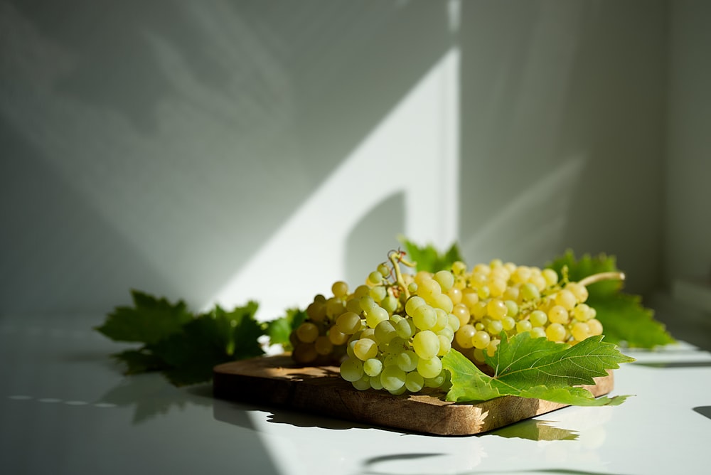 yellow grapes on brown wooden tray