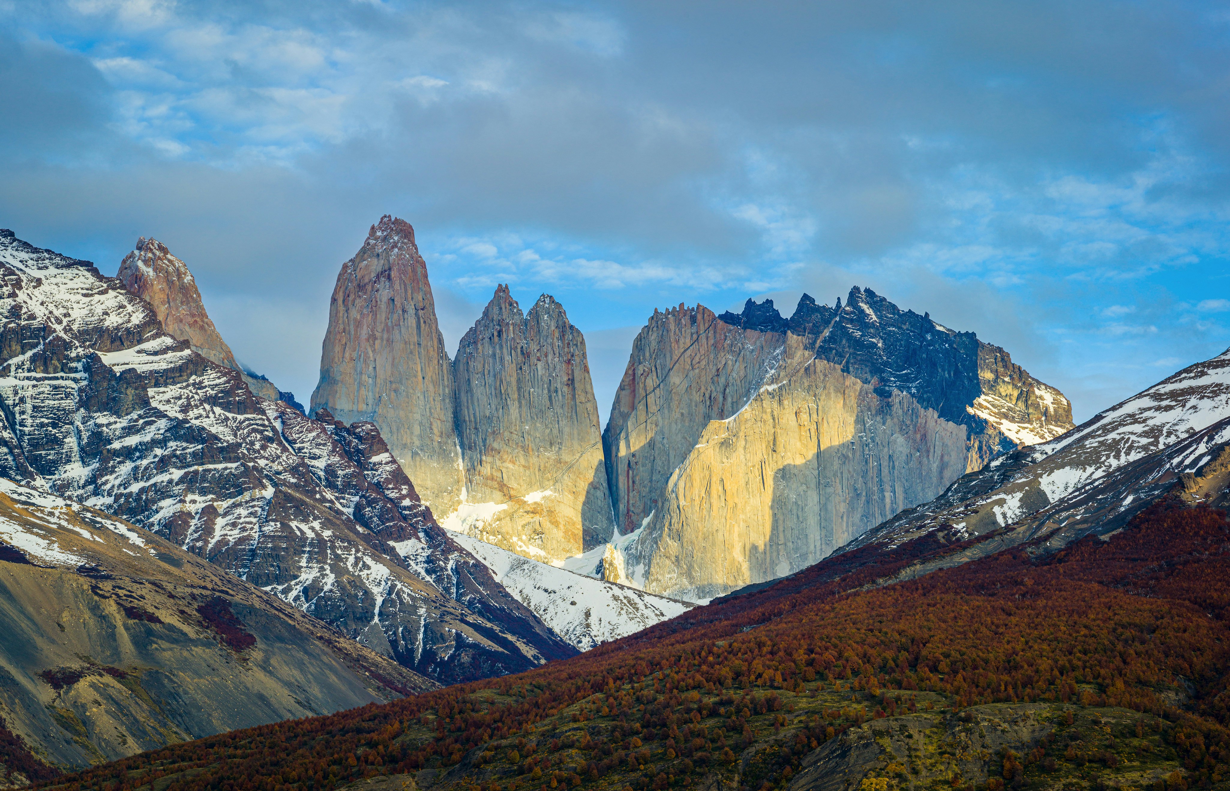 Montañas marrones y blancas bajo nubes