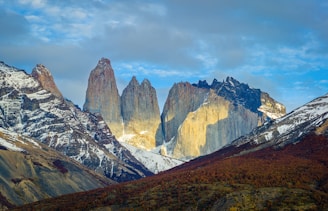 brown and white mountains under white clouds during daytime