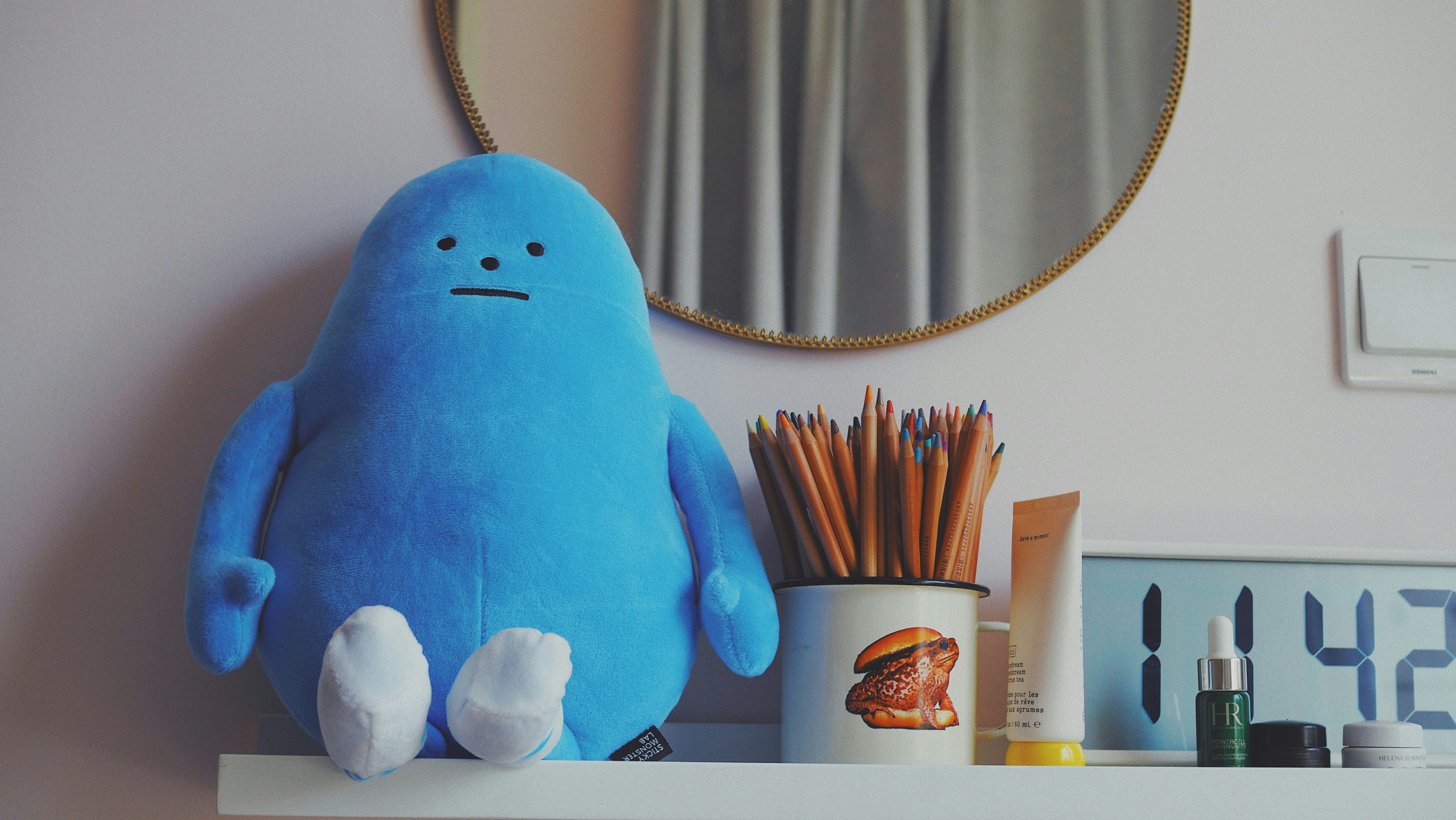 blue bird plush toy on white wooden shelf