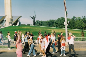 A group of participants walking along a historic street during the Ziarah Kebangsaan tour, with red and white flags visible.