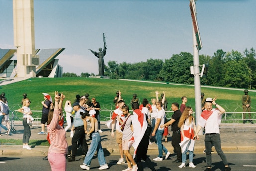 A group of participants walking along a historic street during the Ziarah Kebangsaan tour, with red and white flags visible.