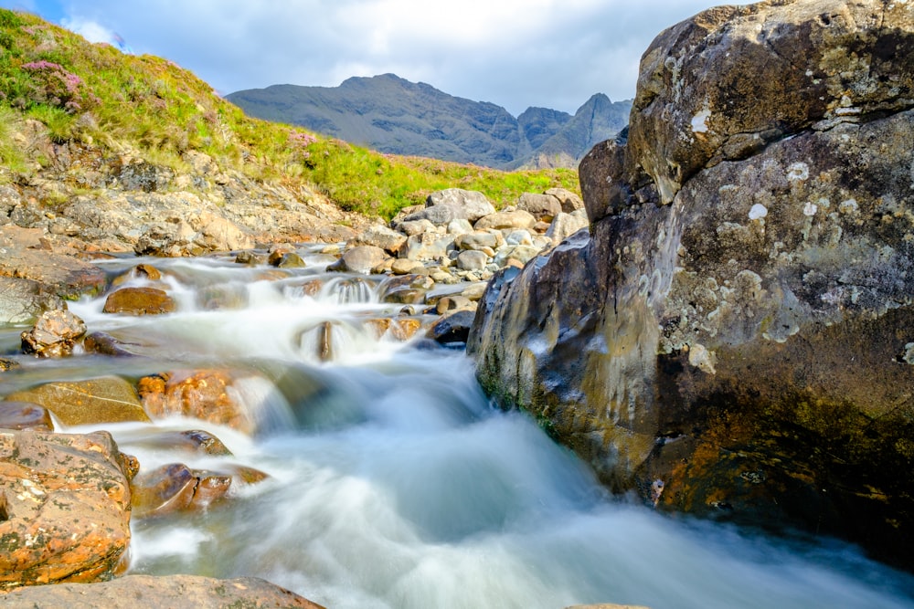 time lapse photography of river between rocky mountains during daytime