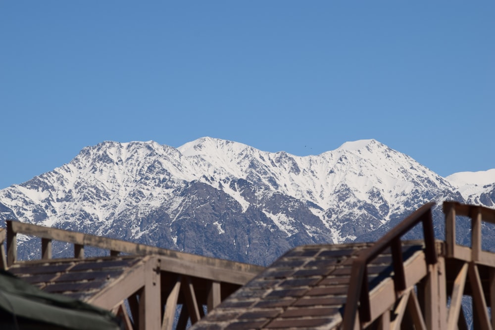 brown wooden fence near snow covered mountain during daytime