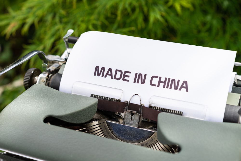 white and black typewriter on green grass during daytime