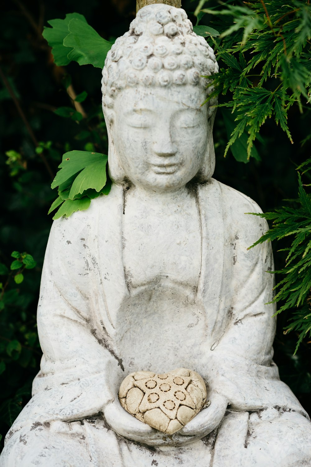 gray concrete statue near green plants