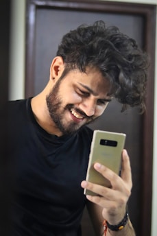 Entrepreneur smiling while checking social media updates on a smartphone.