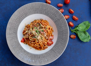pasta with red sauce on white ceramic round plate
