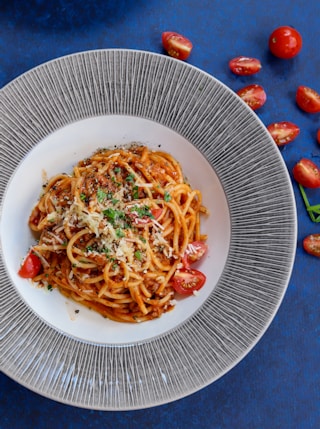 pasta with red sauce on white ceramic round plate