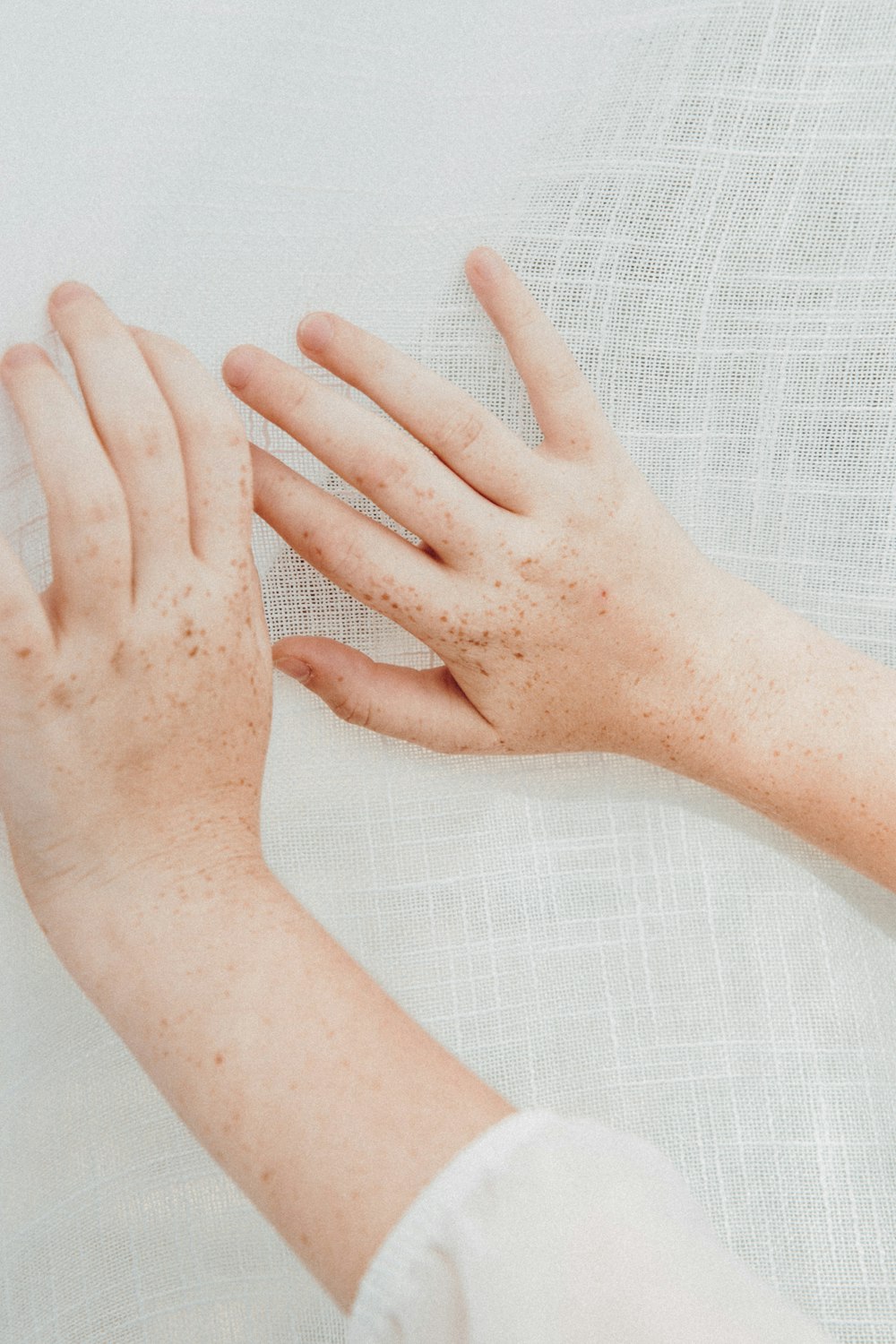 persons left hand on white textile