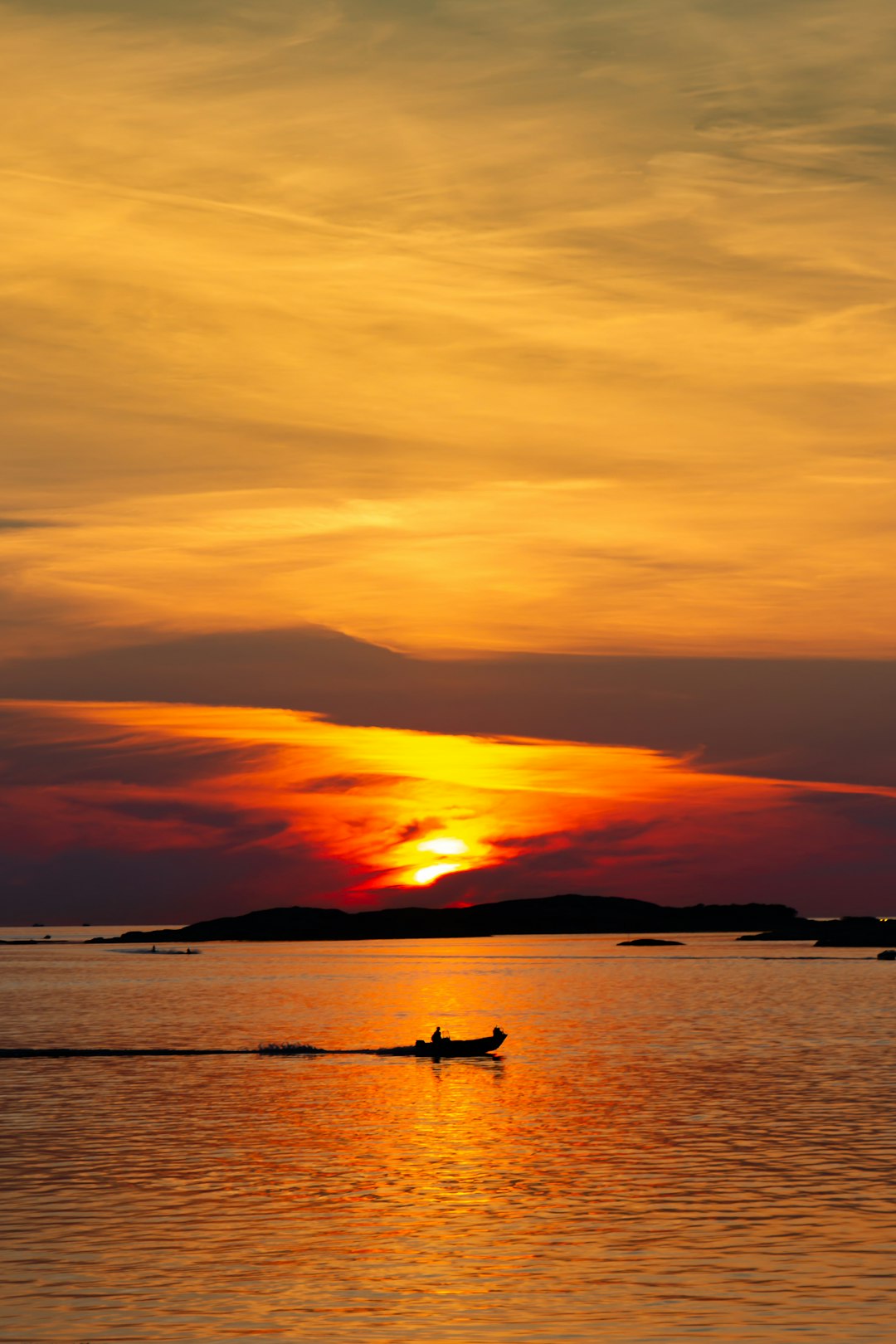silhouette of 2 people riding on boat during sunset