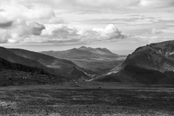 grayscale photo of mountains and clouds