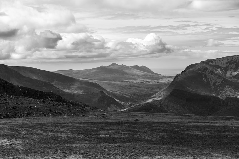 grayscale photo of mountains and clouds