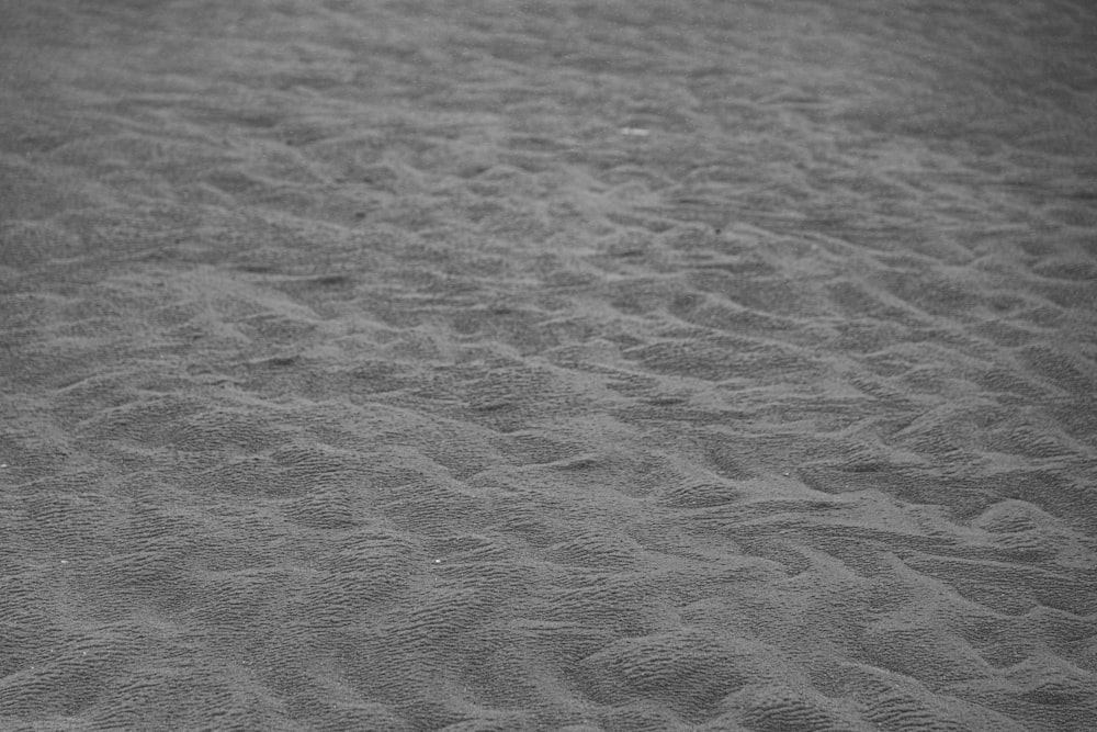 grayscale photo of sand during daytime