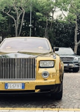A sleek black Rolls Royce Phantom parked elegantly outside a grand venue at sunset.
