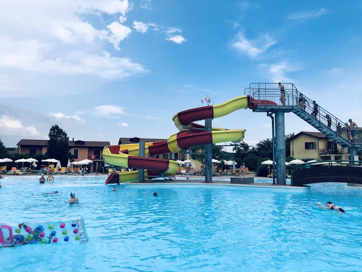 A vibrant wave pool with families splashing and laughing under a bright blue sky.