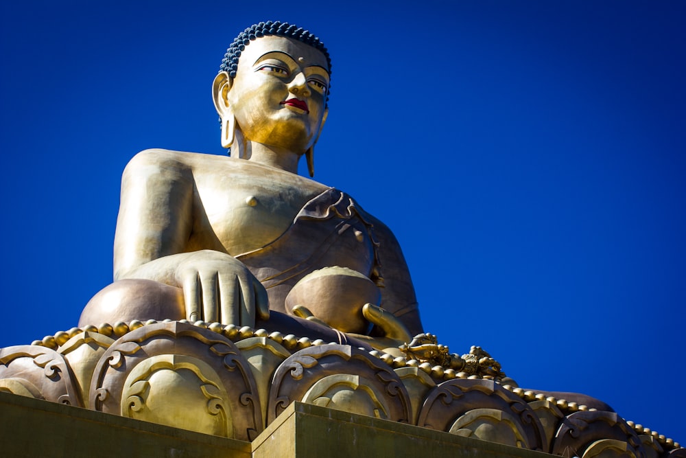 gold buddha statue under blue sky during daytime