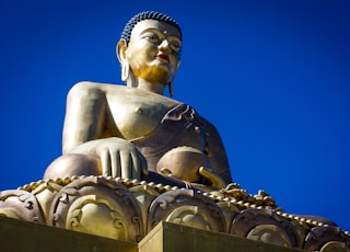 gold buddha statue under blue sky during daytime