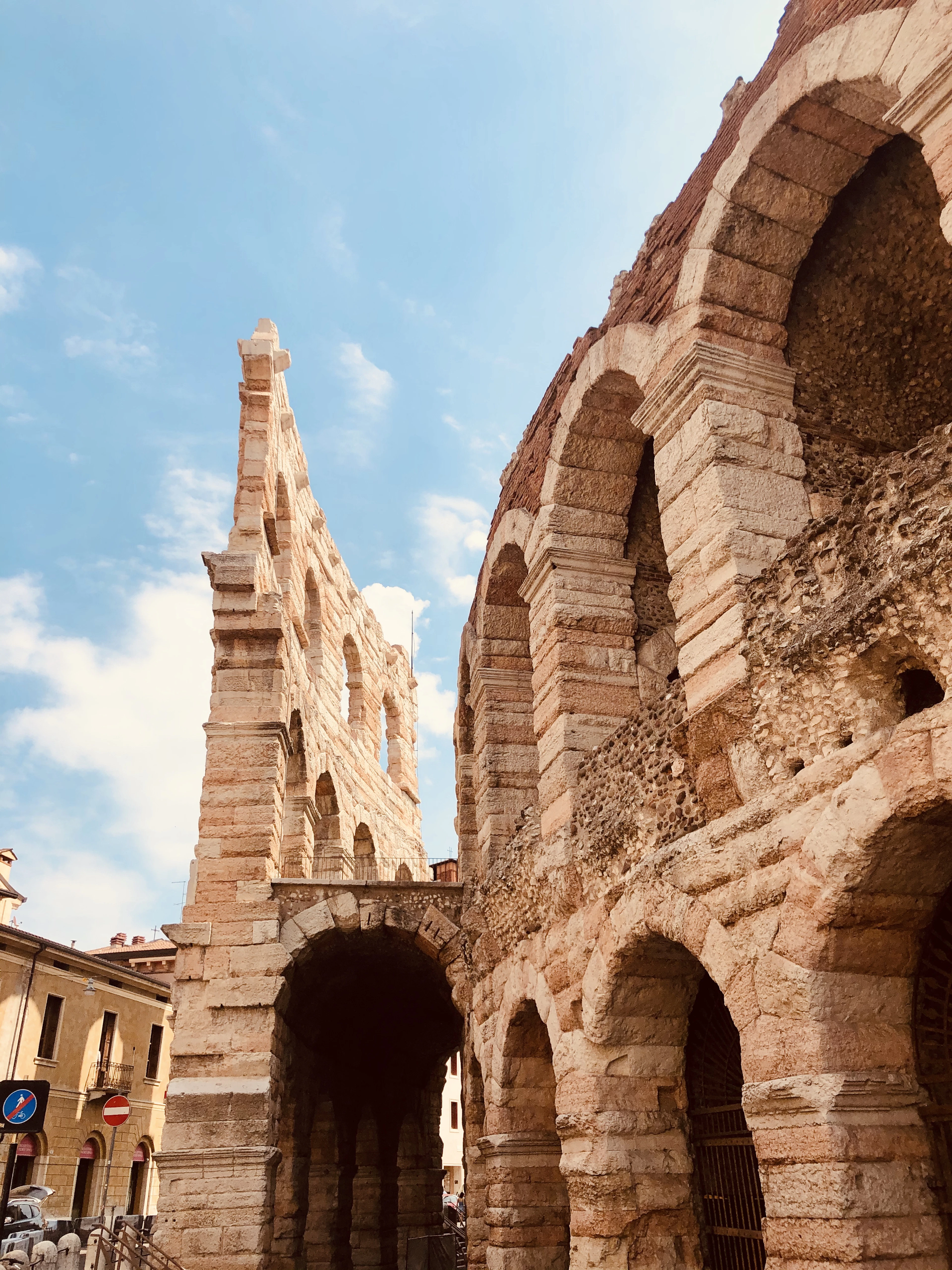 The double tier of Roman arches of the Verona Arena's outer wing against a blue summer sky