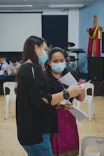 woman in black dress holding white paper