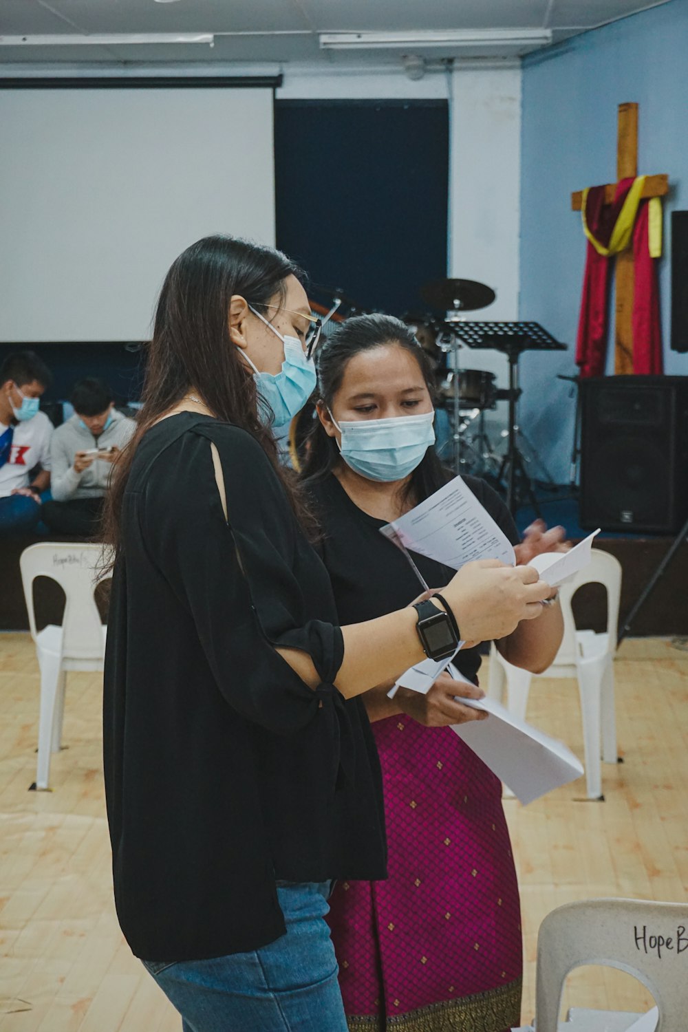 woman in black dress holding white paper