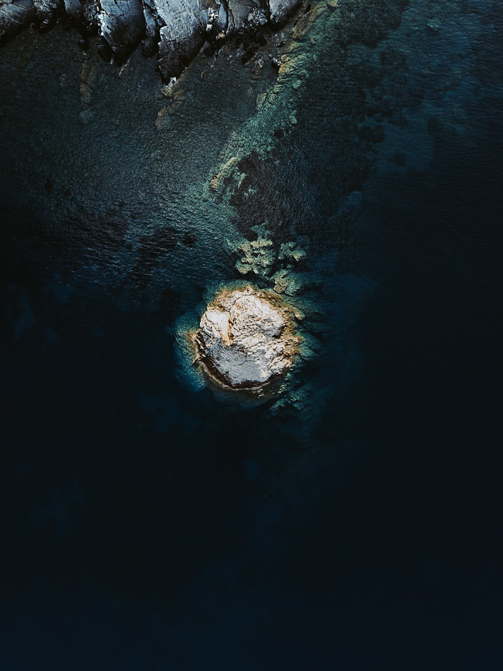 Piedra marrón y negra sobre el agua