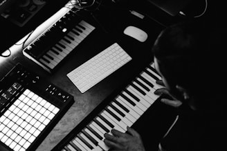 grayscale photo of person playing piano