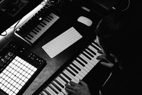 grayscale photo of person playing piano