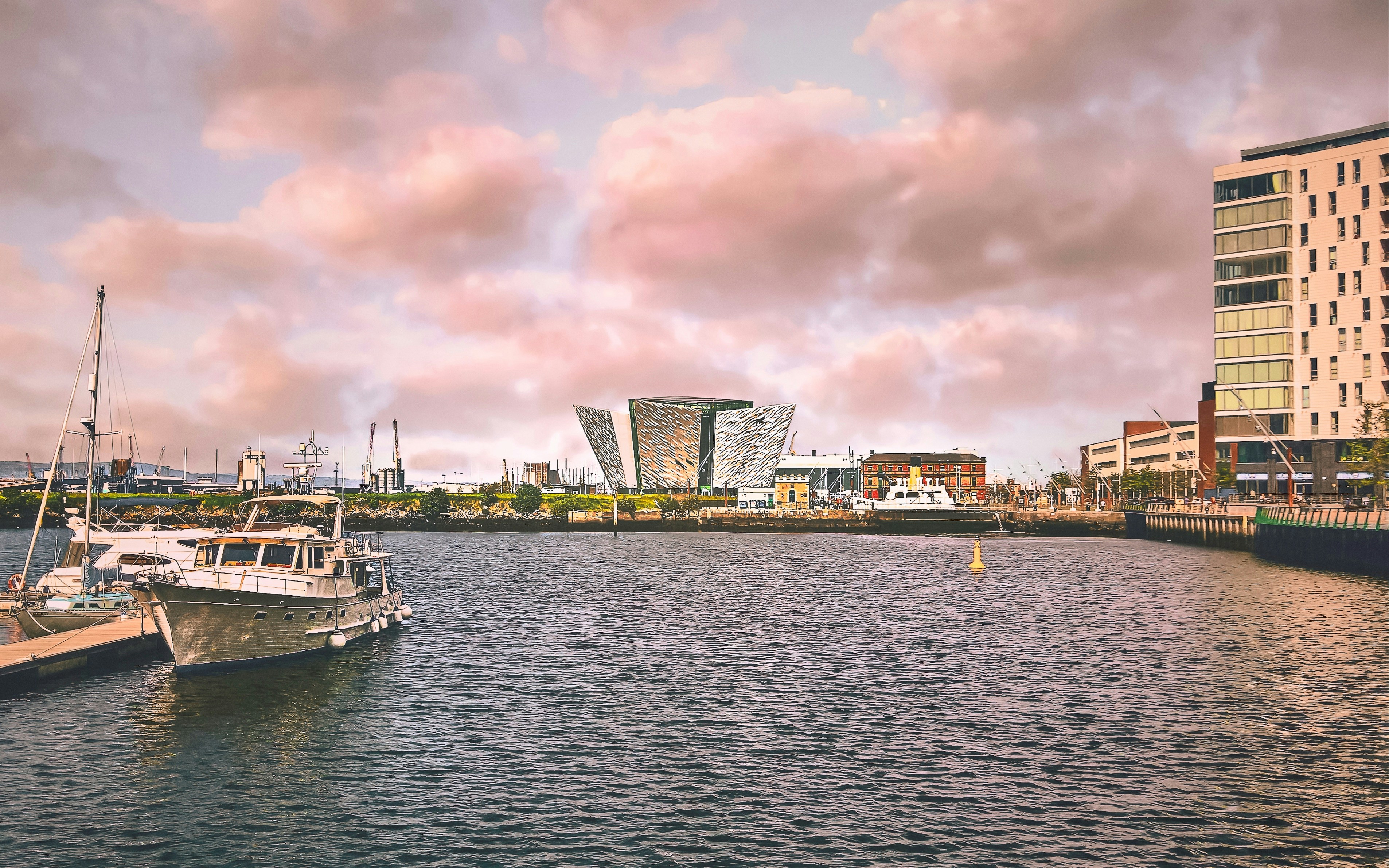 white boat on body of water near city buildings during daytime