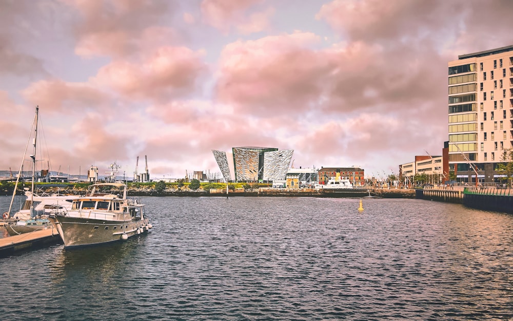 white boat on body of water near city buildings during daytime