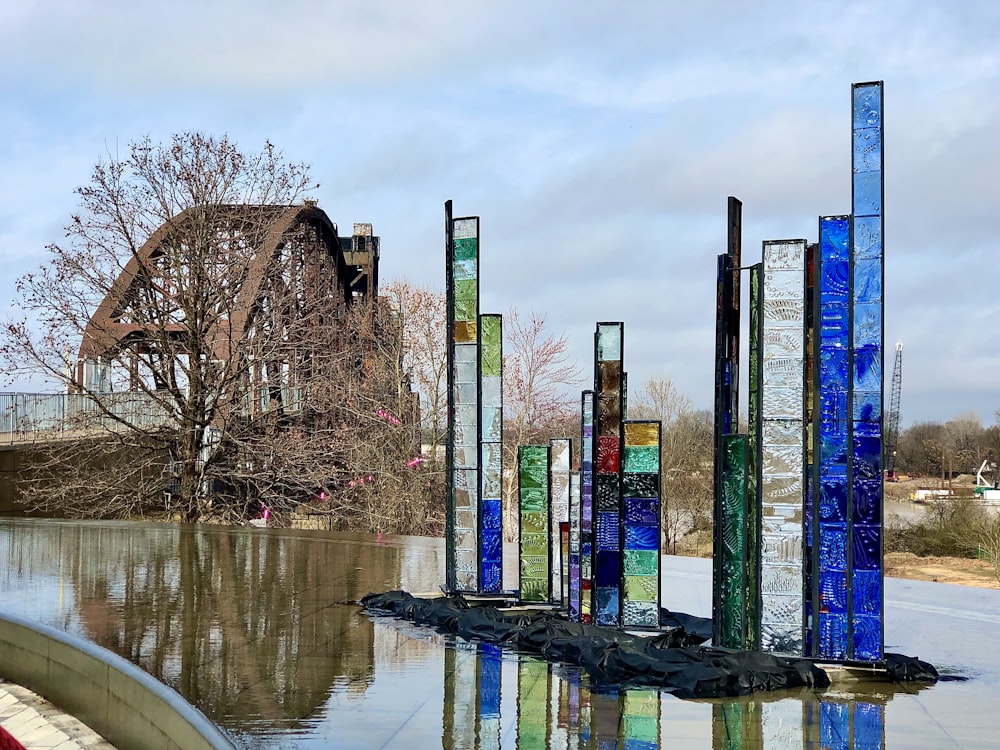 Edificio di vetro blu, verde e rosa vicino allo specchio d'acqua durante il giorno