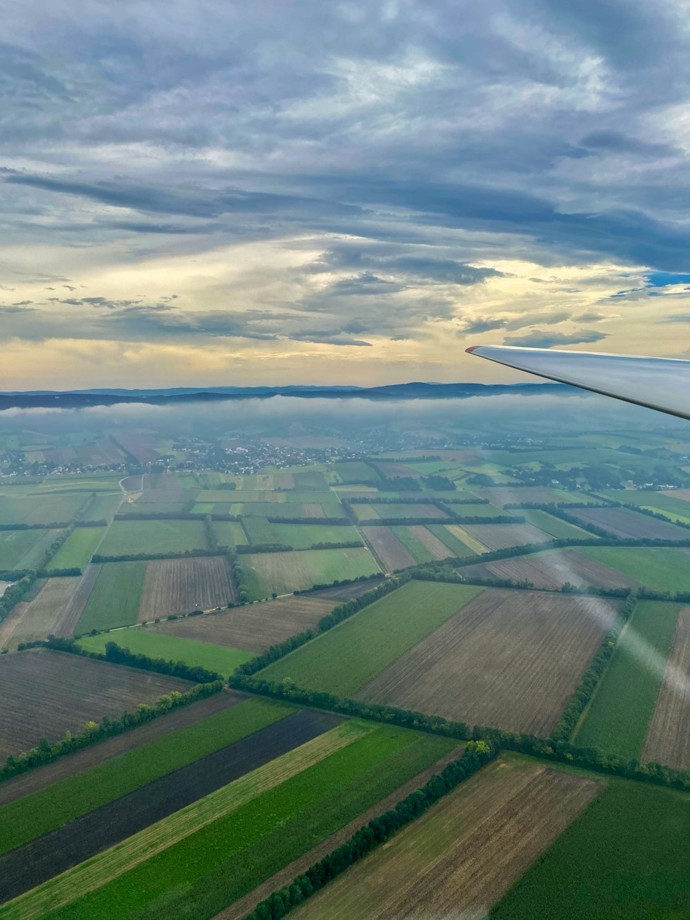 green grass field under cloudy sky during daytime