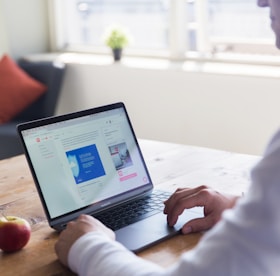 person using macbook pro on table