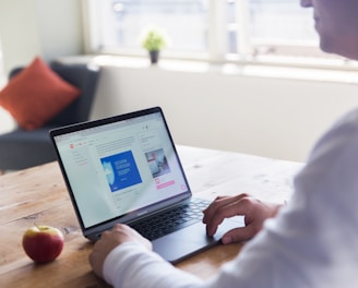 person using macbook pro on table