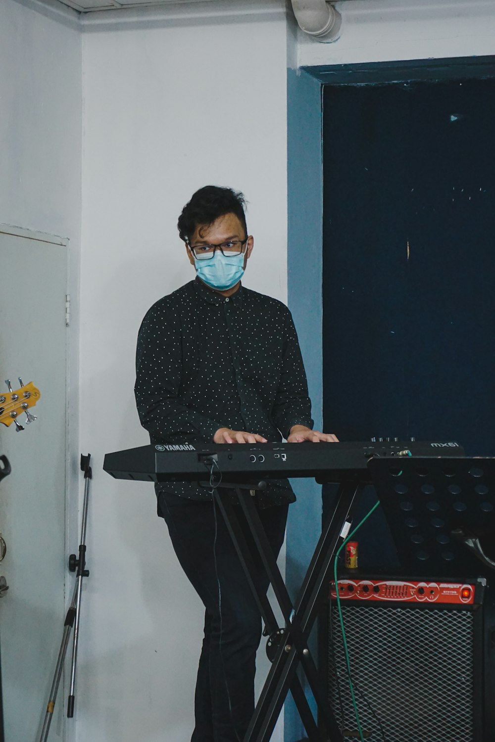 man in black and white checkered dress shirt playing electric keyboard