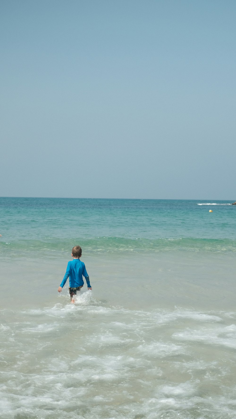 man in blue shirt surfing on sea during daytime