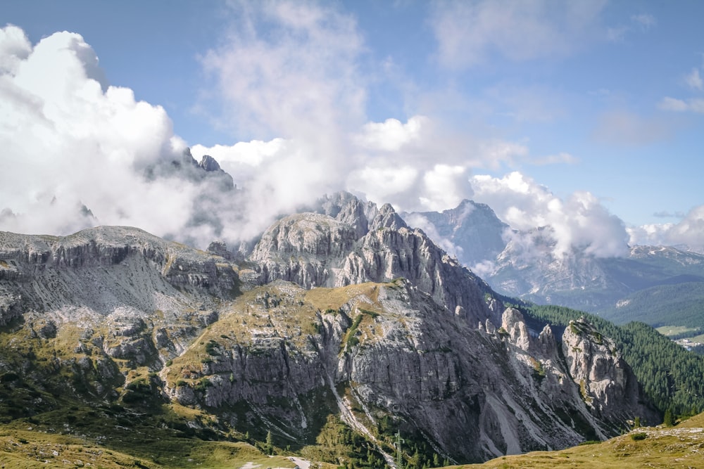 green and brown mountain under white clouds and blue sky during daytime